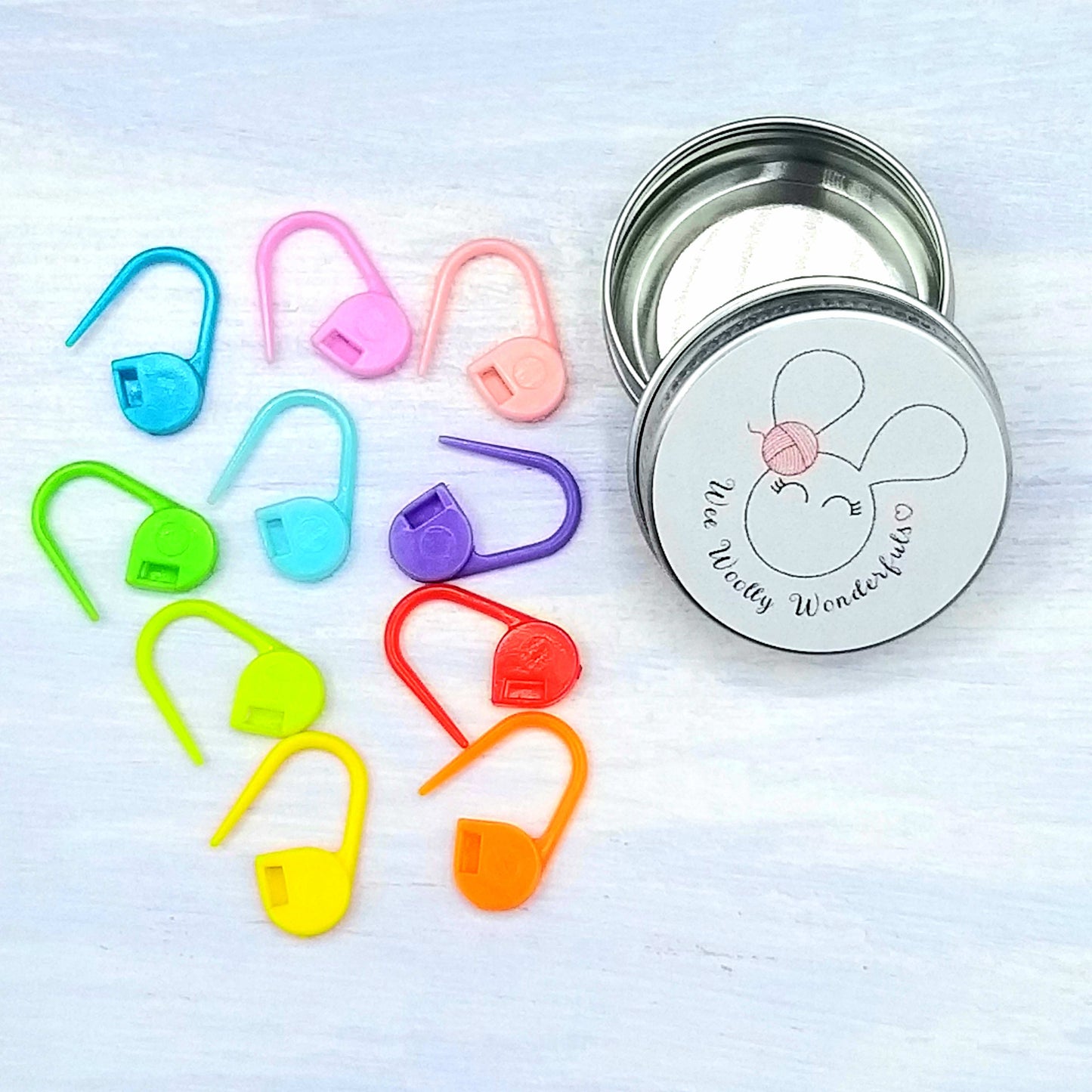 Rainbow stitch markers in tin
