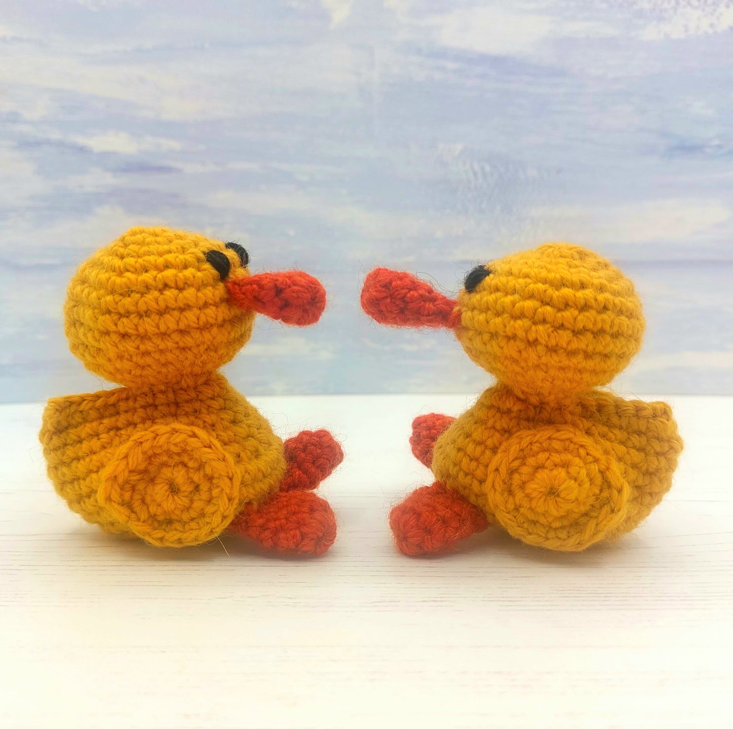 Two crochet chicks sitting opposite each other
