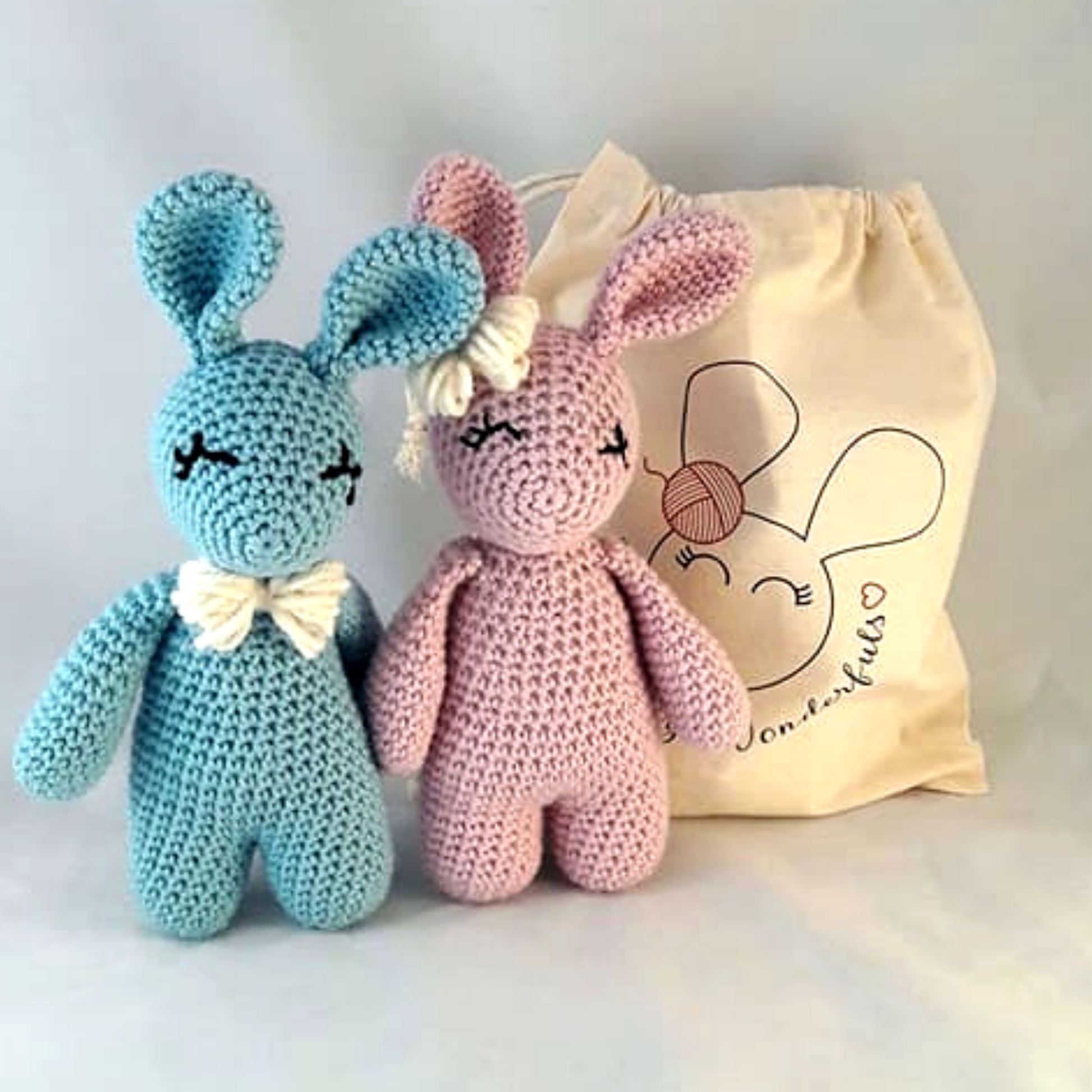 Boy and Girl Crochet Rabbits next to project bag