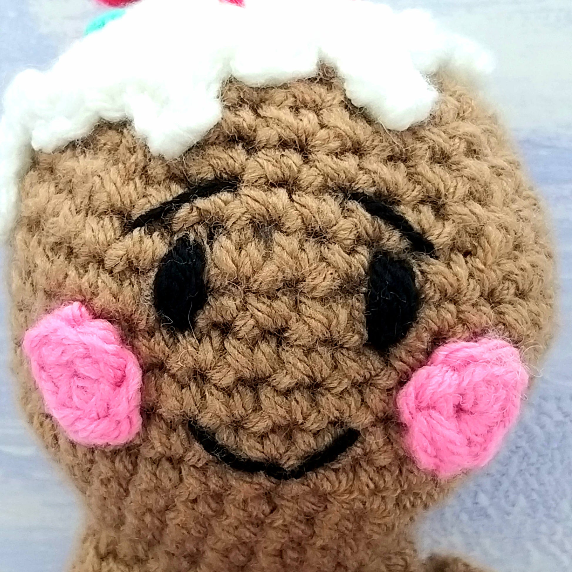 Close up of stitches on crochet gingerbread man's face