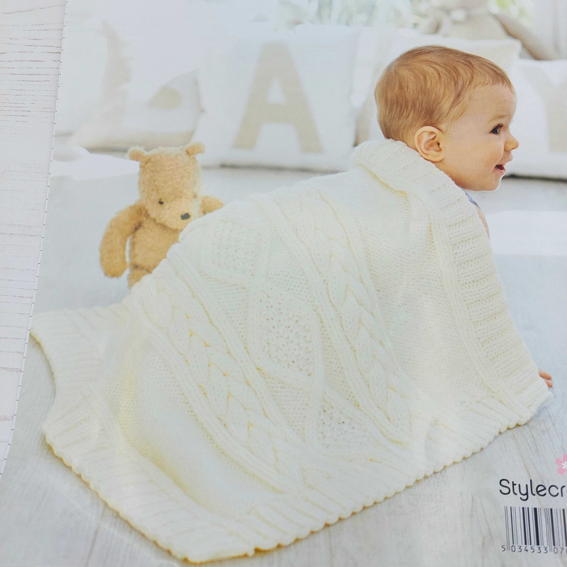 Baby with cream knitted blanket